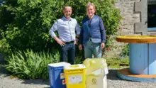 Guy Le Bouter et Bruno Robert, responsable de secteur La Collecte Médicale, présentent les containers de couleur qui correspondent chacun à un type de déchets d'élevage.