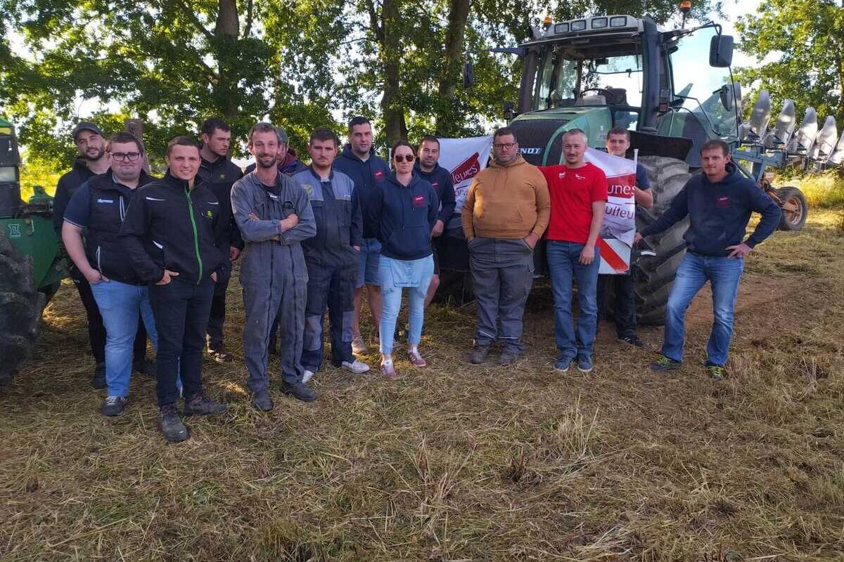 Les Jeunes Agriculteurs du canton de Plénée-Jugon groupés devant un tracteur - Illustration Du maïs semé dans une friche à Plestan