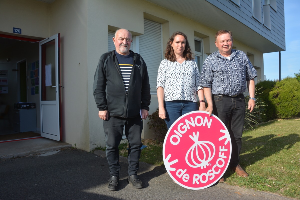 Robert Jézéquel, Nelly Maguet et Jean-Louis Rungoat posent devant le logo Oignon de Roscoff - Illustration Les surfaces d’oignon  de Roscoff en progression