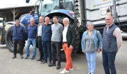 Un groupe de personnes devant un tracteur