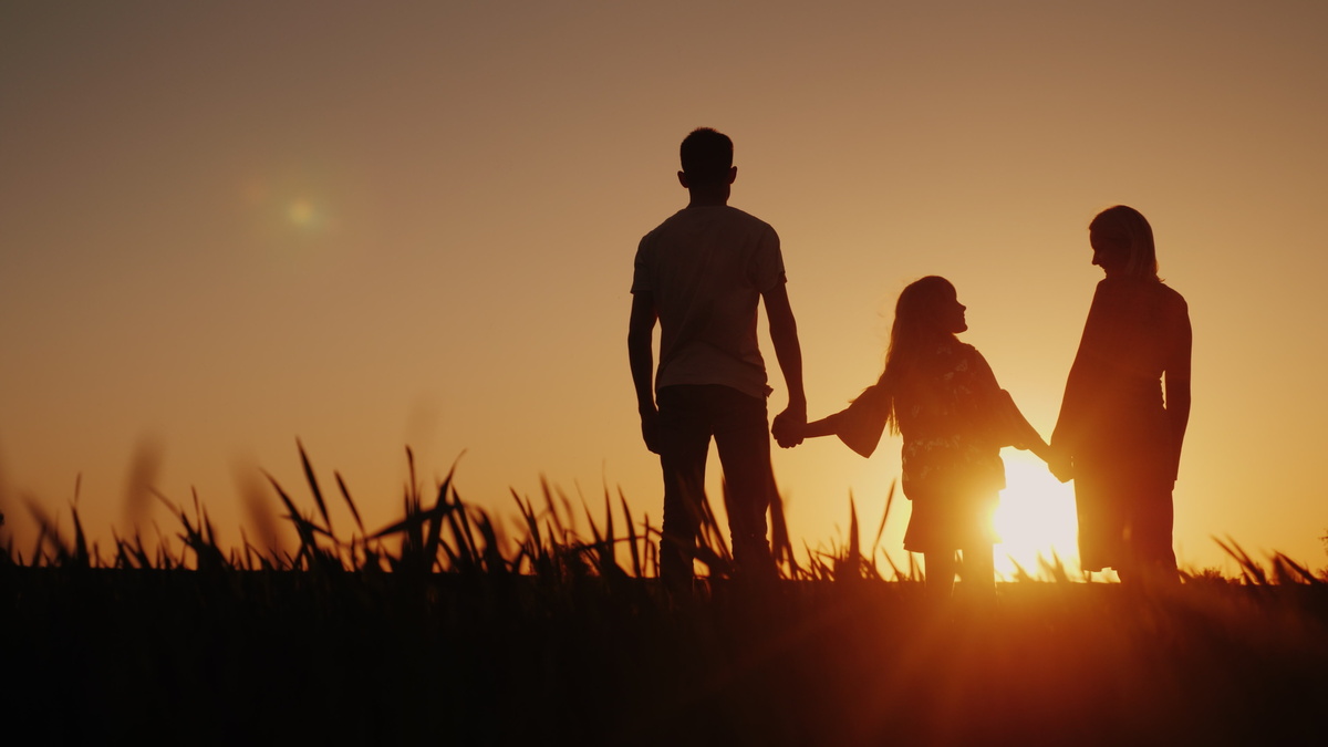 Une famille qui se tient la main devant un coucher de soleil - Illustration Entre vie professionnelle et personnelle : Trouver un équilibre