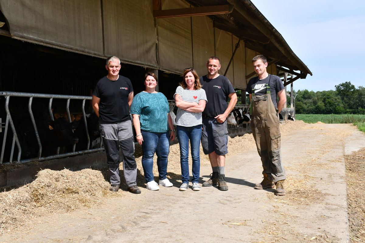 Toutes les personnes travaillant sur la ferme devant la stabulation des génisses - Illustration Partir en vacances grâce au service de remplacement