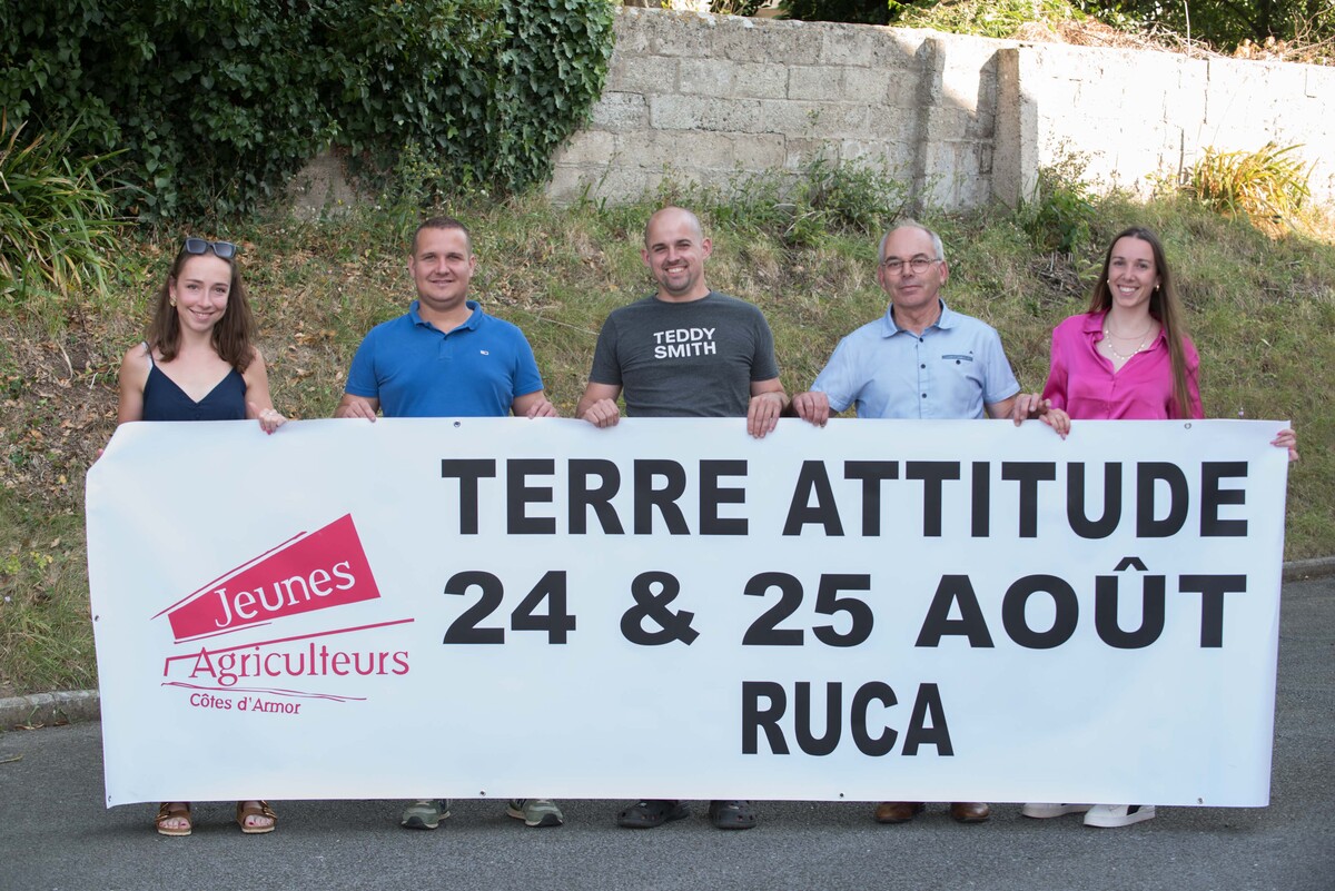 Cinq personnes tiennent une banderole pour annoncer la fête agricole Terre Attitude 2024. - Illustration Terre Attitude sur les rails à Ruca