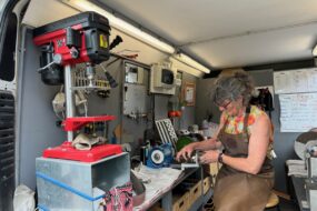 Dans sa camionnette - atelierne, une rémouleuse en train d'affûter une lame.