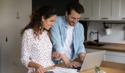 Jeune couple en train de faire ses papiers administratifs devant un ordinateur