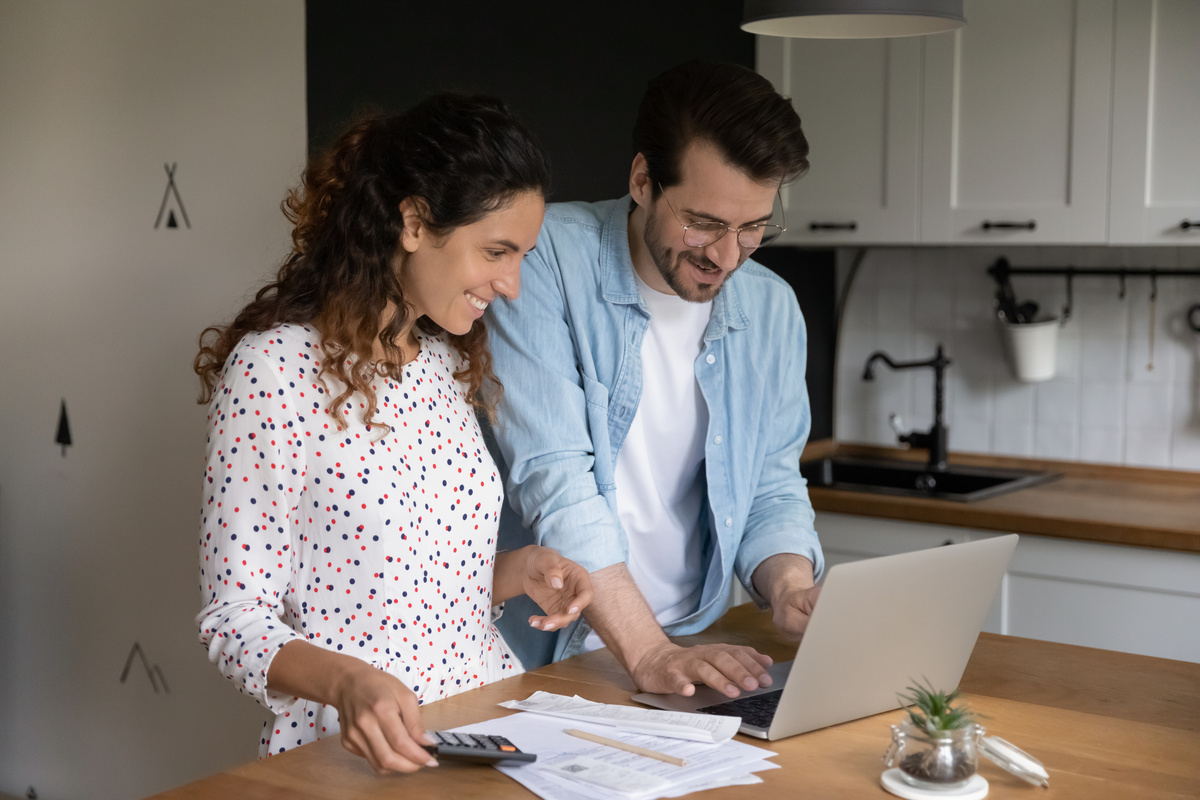 Jeune couple en train de faire ses papiers administratifs devant un ordinateur - Illustration Acquisition de congés payés pendant l’arrêt de travail : les nouvelles règles