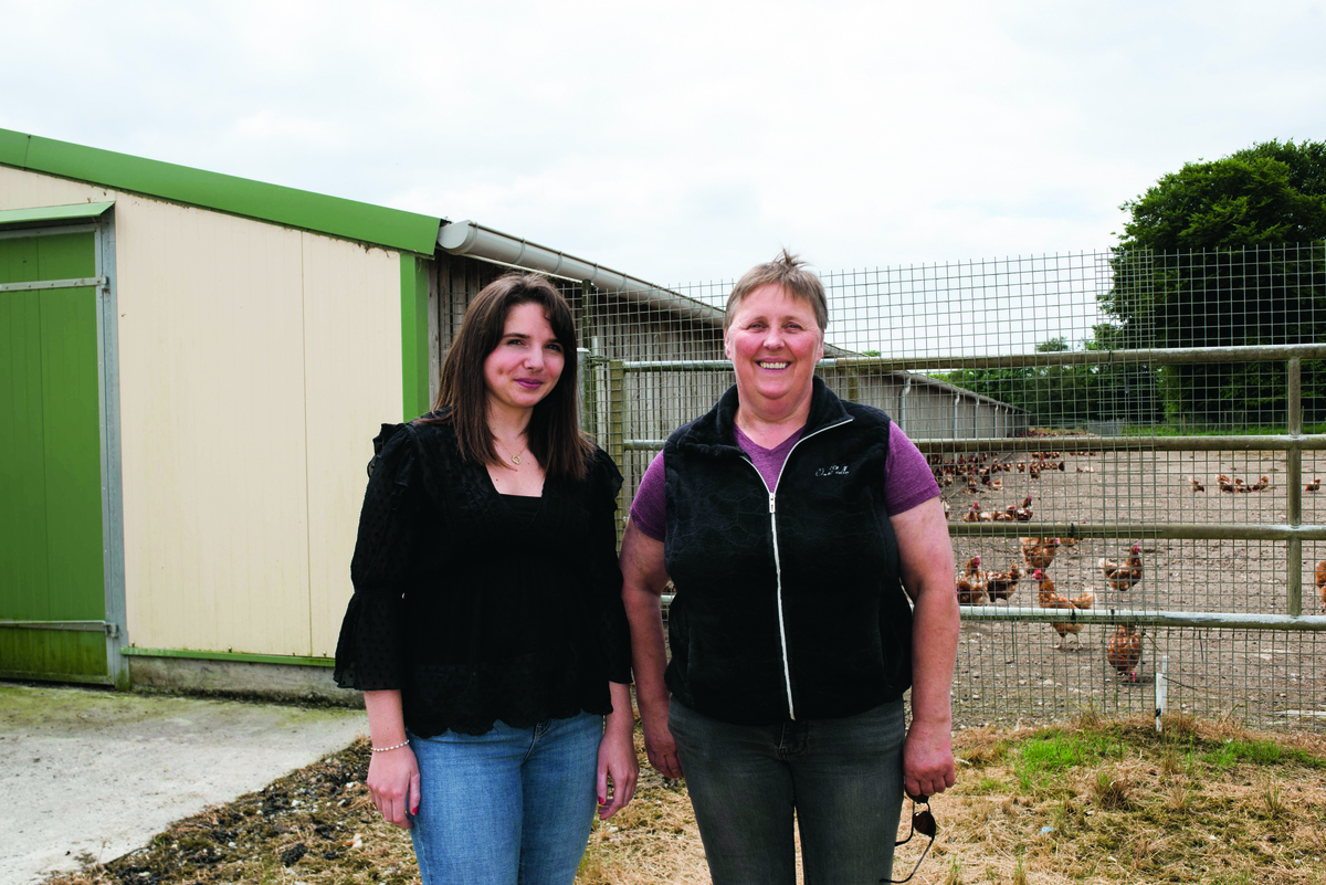 Deux femmes devant un bâtiment de poules pondeuses. - Illustration Le parcours de Chloé jusqu’au poulailler de Martine