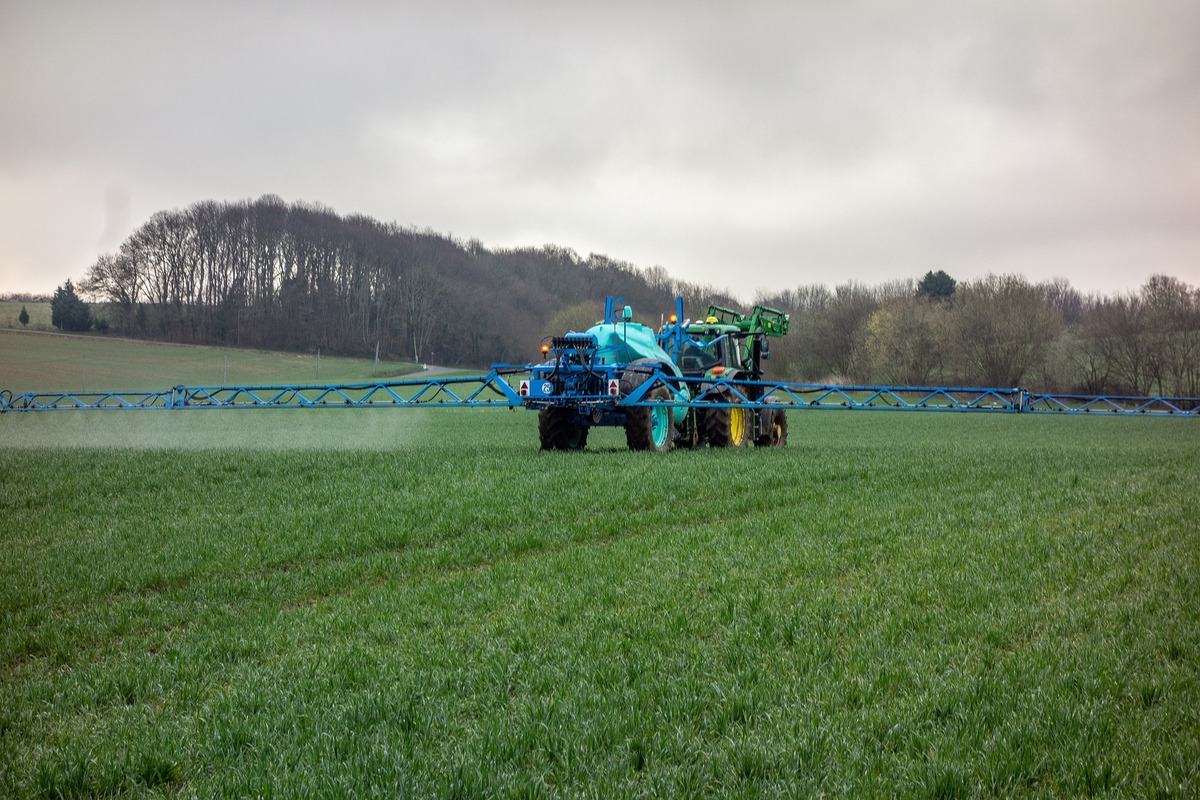 Tracteur et pulvérisateur travaillant au champ - Illustration Des solutions concrètes pour les victimes des pesticides