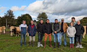 Les éleveurs sur une parcelle avec des Aubracs dans le fond