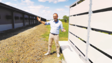 un homme devant des bâtiments agricoles