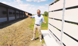 un homme devant des bâtiments agricoles