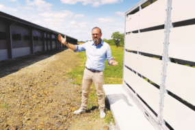 un homme devant des bâtiments agricoles