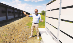 un homme devant des bâtiments agricoles