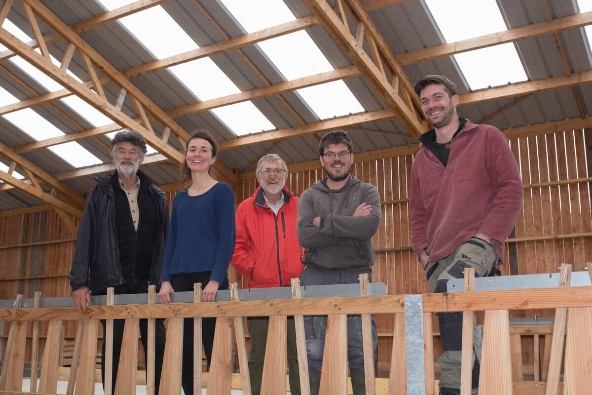 Cinq personnes dans une bergerie en construction - Illustration Une rando-fermes reliant de jeunes installés