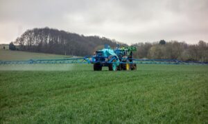 Un tracteur en train de pulvériser dans un champ