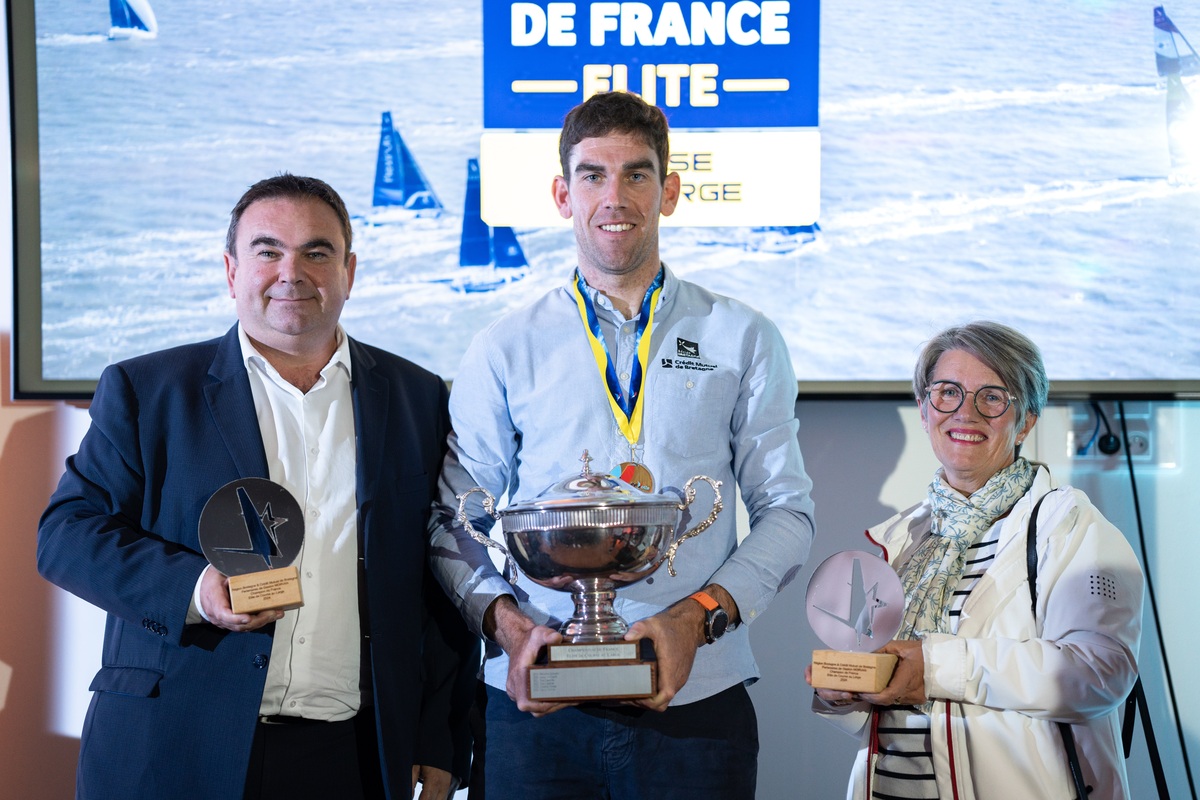 Gaston Morvan avec sa coupe de champion de France élite de course au large entouré de Pierre Pouliquen, vice-Président du Conseil régional, et de Marie-Noëlle Soulet, administratrice de la Fédération du Crédit Mutuel de Bretagne.