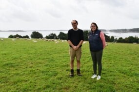 Michel Le Derf et Morgane Talidec avec les moutons et la mer dans le fond