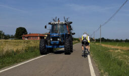 un tracteur et des vélos se croisent sur une route de campagne