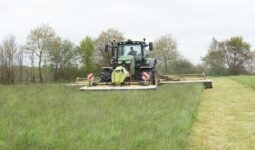 Un tracteur réalise un chantier de fauche de l'herbe.