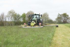 Un tracteur réalise un chantier de fauche de l'herbe.