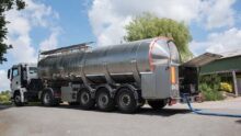 Un camion de collecte du lait dans la cour d'une ferme.