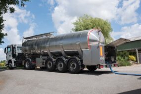 Un camion de collecte du lait dans la cour d'une ferme.