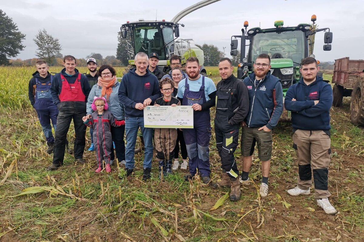 Un groupe de jeunes agriculteurs devant une ensileuse et un tracteur - Illustration Ensilage solidaire des JA de Plénée-Jugon