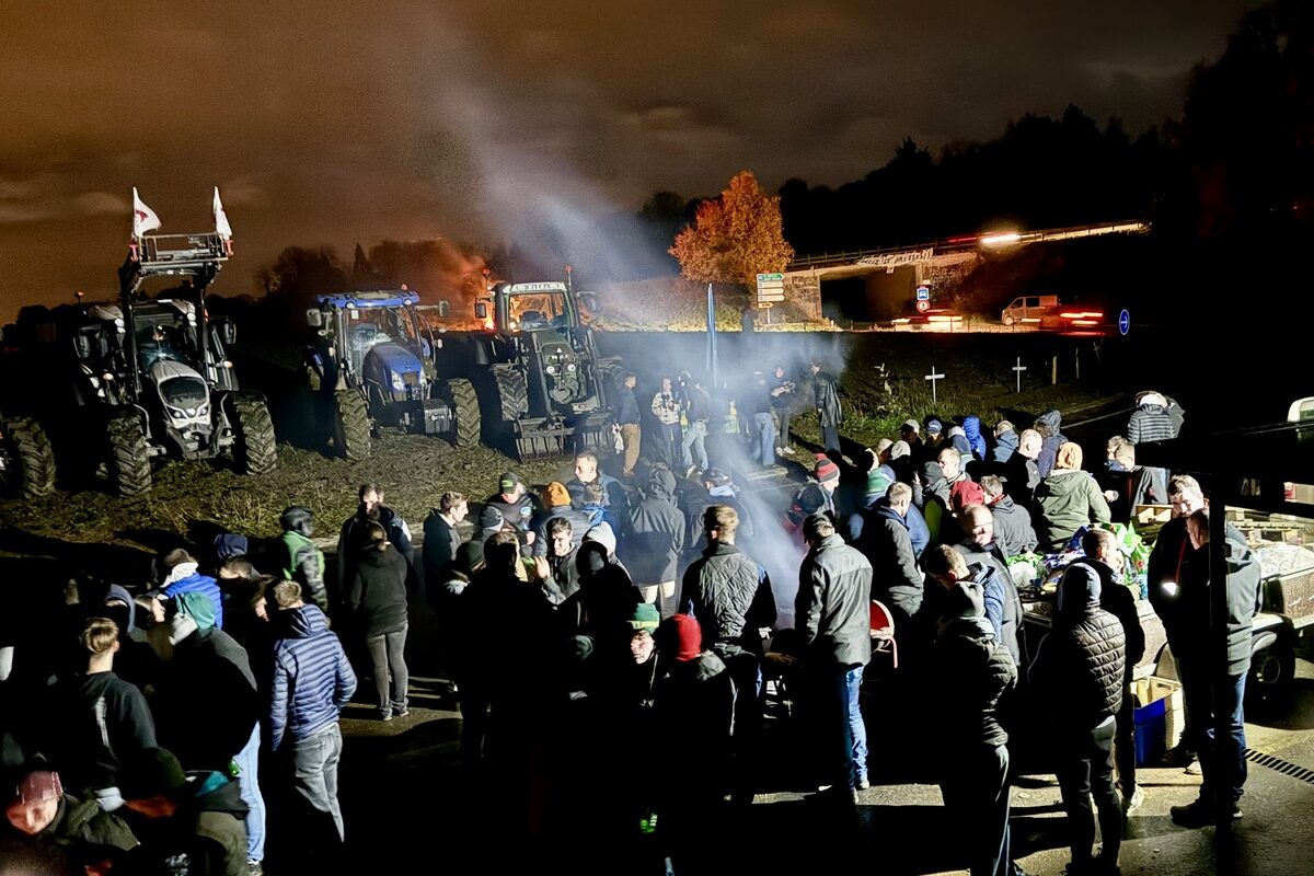 Des agriculteurs manifestant au bord d'un rond-point où sont garés des tracteurs. - Illustration « Sacrifiés comme  monnaie d’échange »