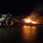 Feu de colère dans la nuit avec un tracteur à côté