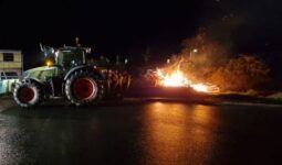 Feu de colère dans la nuit avec un tracteur à côté