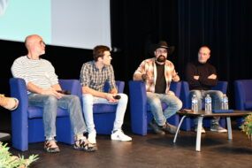 Les quatre intervenants en table ronde dans la salle de conférence