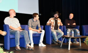 Les quatre intervenants en table ronde dans la salle de conférence