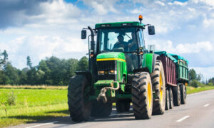 Un tracteur avec une remorque sur la route