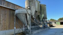 Des silos d'aliments à côté d'un bâtiment d'élevage laitier