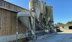 Des silos d'aliments à côté d'un bâtiment d'élevage laitier