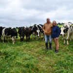 Les éleveurs devant les vaches laitières au pâturage.