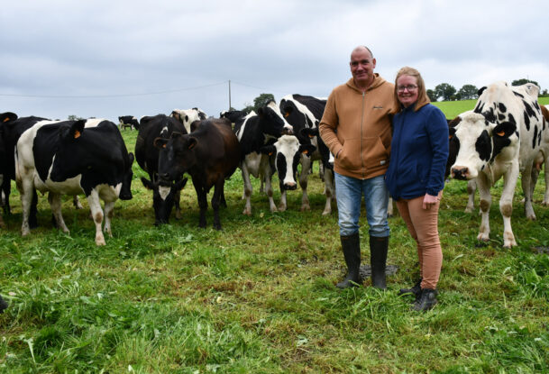 Les éleveurs devant les vaches laitières au pâturage.