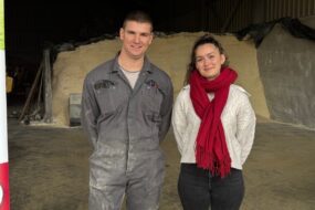 Un éleveur de porc et son apprentie devant un silo de mais grain broyé