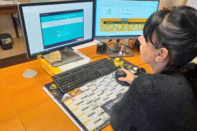 Une femme devant 2 écrans d'ordinateur