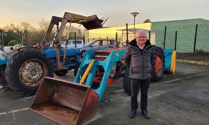 Michel Emily devant des tracteurs