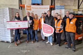 Un groupe de personnes pour la remise d'un don de 15 000 côtes de porc à des Banques Alimentaires