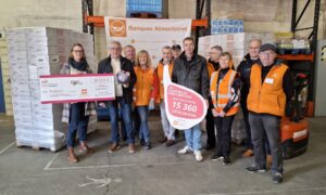 Un groupe de personnes pour la remise d'un don de 15 000 côtes de porc à des Banques Alimentaires