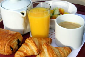 PETIT DÉJEUNER AVEC CAFÉ, JUS D'ORANGE ET PAIN AU CHOCOLAT