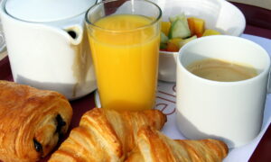 PETIT DÉJEUNER AVEC CAFÉ, JUS D'ORANGE ET PAIN AU CHOCOLAT