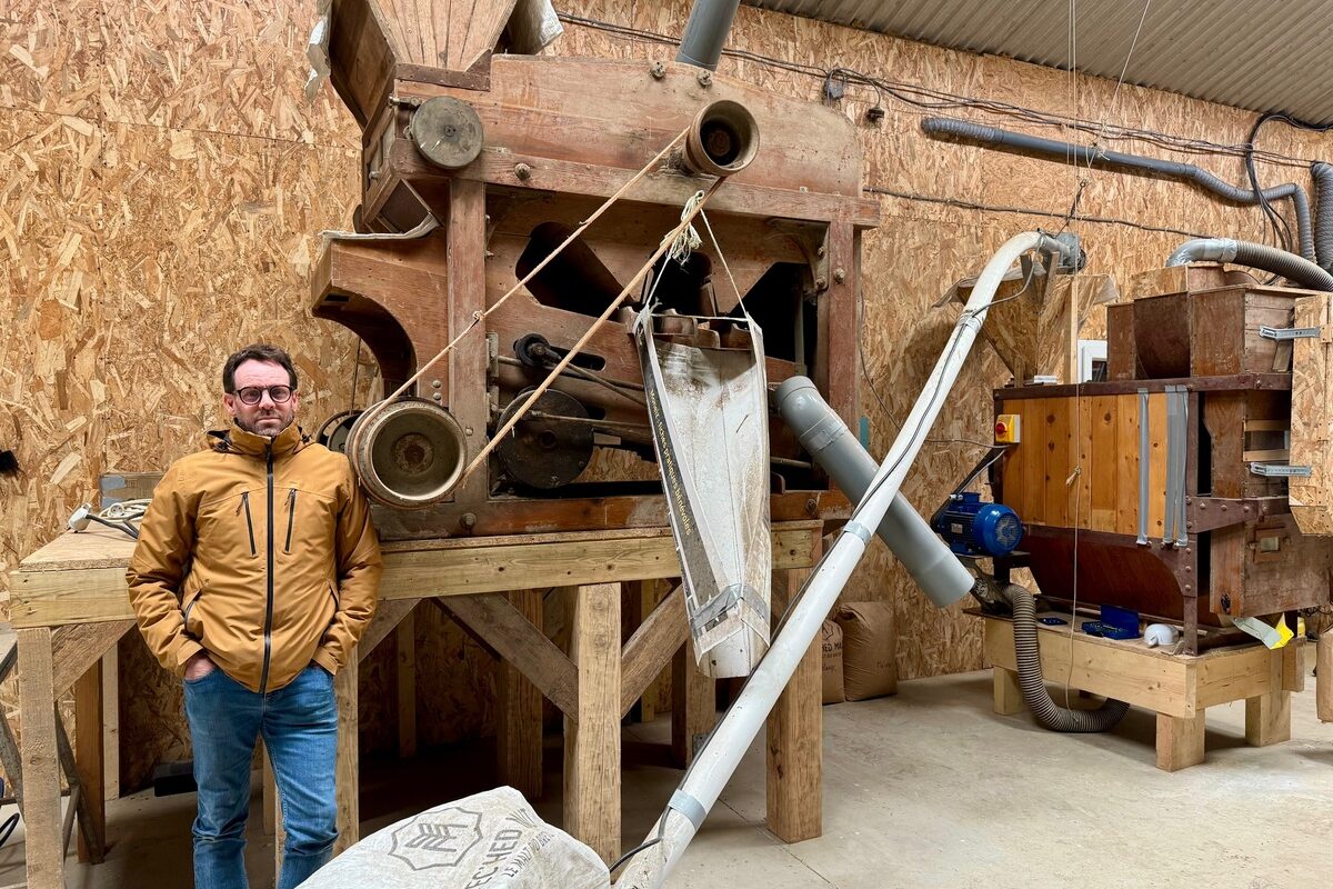 Un paysan pastier devant deux machines anciennes en bois permettant de travailler le grain.  - Illustration 10 formes de pâtes fabriquées : Paysan pastier  pour nourrir le pays