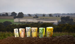 montage de billets devant un bâtiment agricole