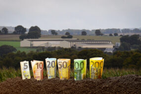 montage de billets devant un bâtiment agricole