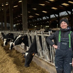 Une jeune éleveuse davant ses vaches à l'auge