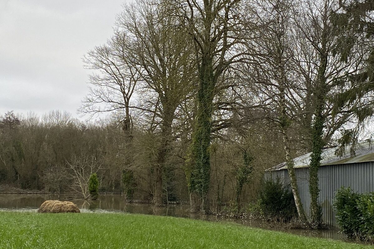 Un bâtiment inondé par l'eau sortie du lit de la rivière - Illustration Besoin de soutien aux sinistrés