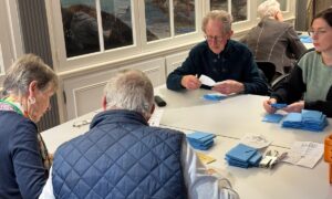 Quatre personnes en train de dépouiller des bulletins de vote.